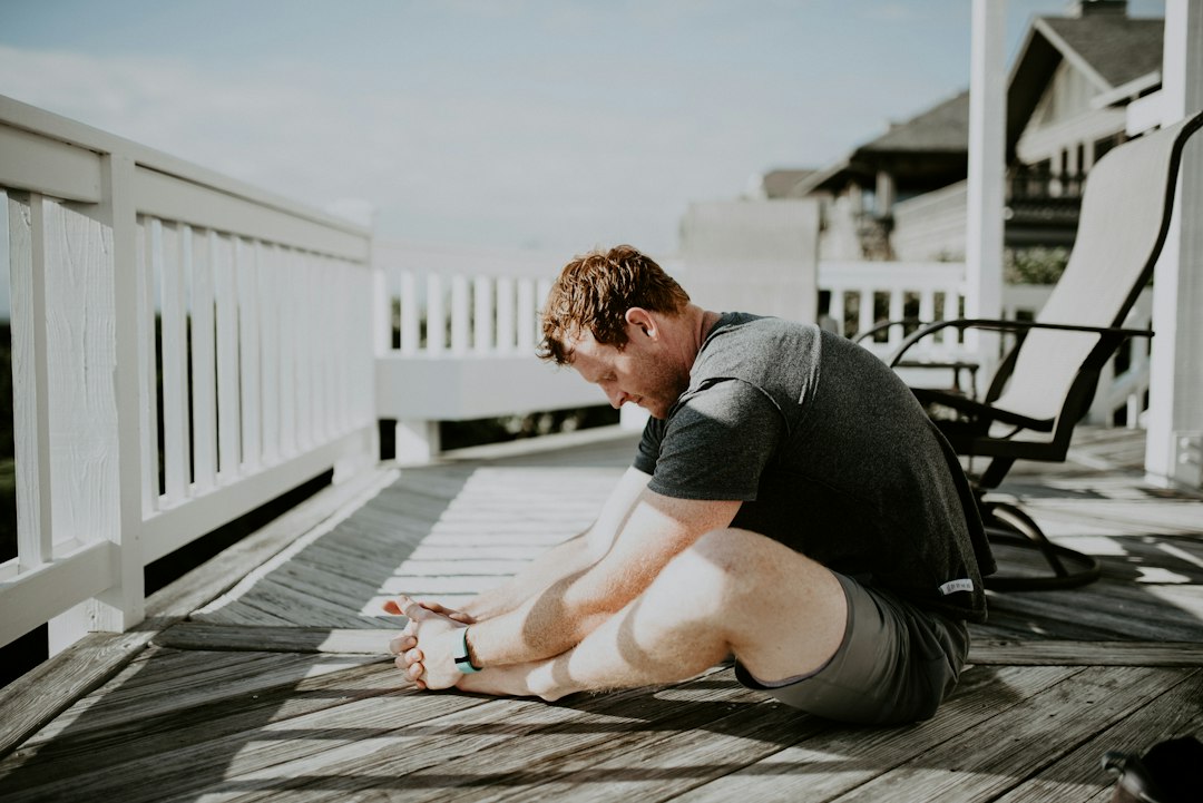 Person doing a gentle morning stretch on the beach in soft sunlight
