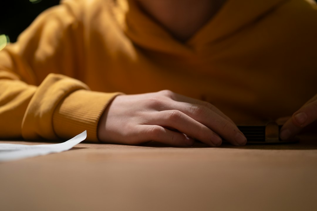 Person seated at a table writing on paper, focused on getting started