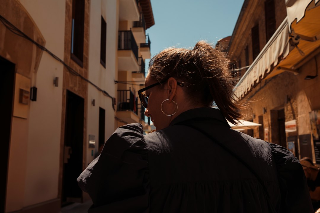 Woman walking with confidence through a sunlit alleyway, golden light around her